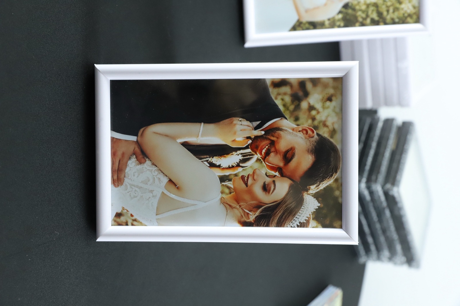 Set complet la eveniment: rame albe 10×15, magneți acrilici și printuri foto proaspete pe masă neagră